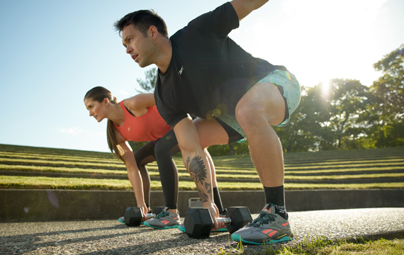 Woman and Men training outside with Reebok training apparel and shoes