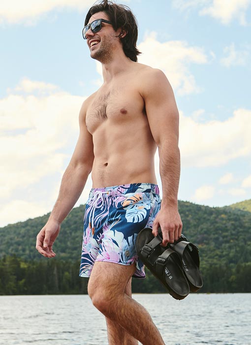 Homme qui marche sur la plage avec un short de plage bleu